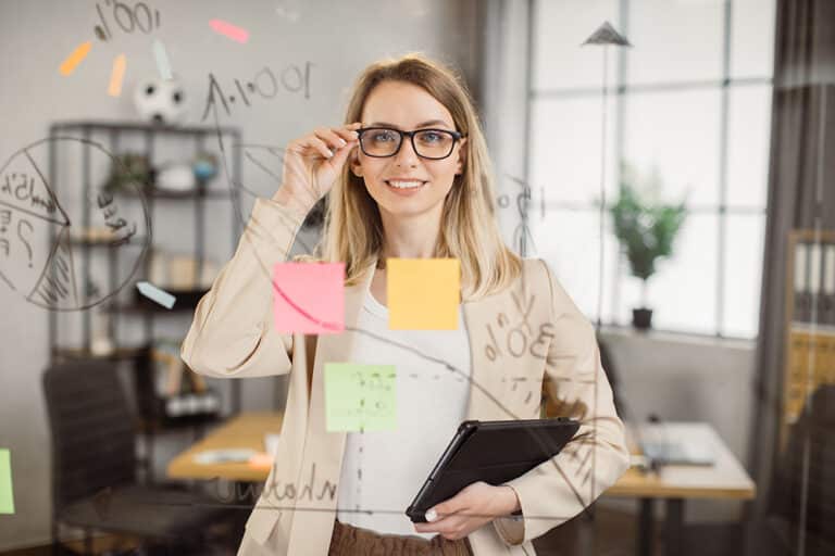 Female project manager holding tablet and smiling at office