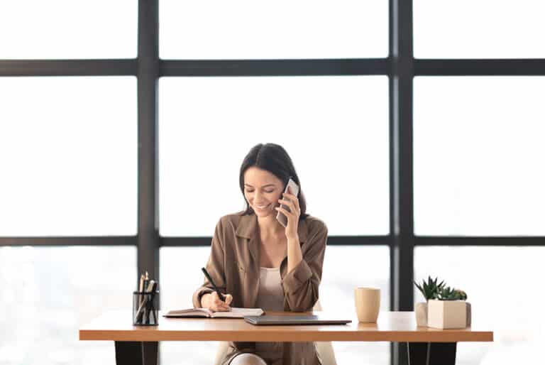 Portrait of smiling manager making phone call at office